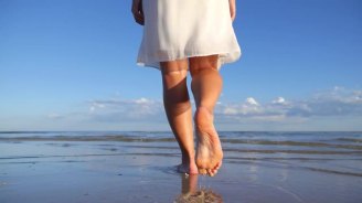 woman-legs-walking-on-beach-with-the-sea-water_nznnikave__m0000